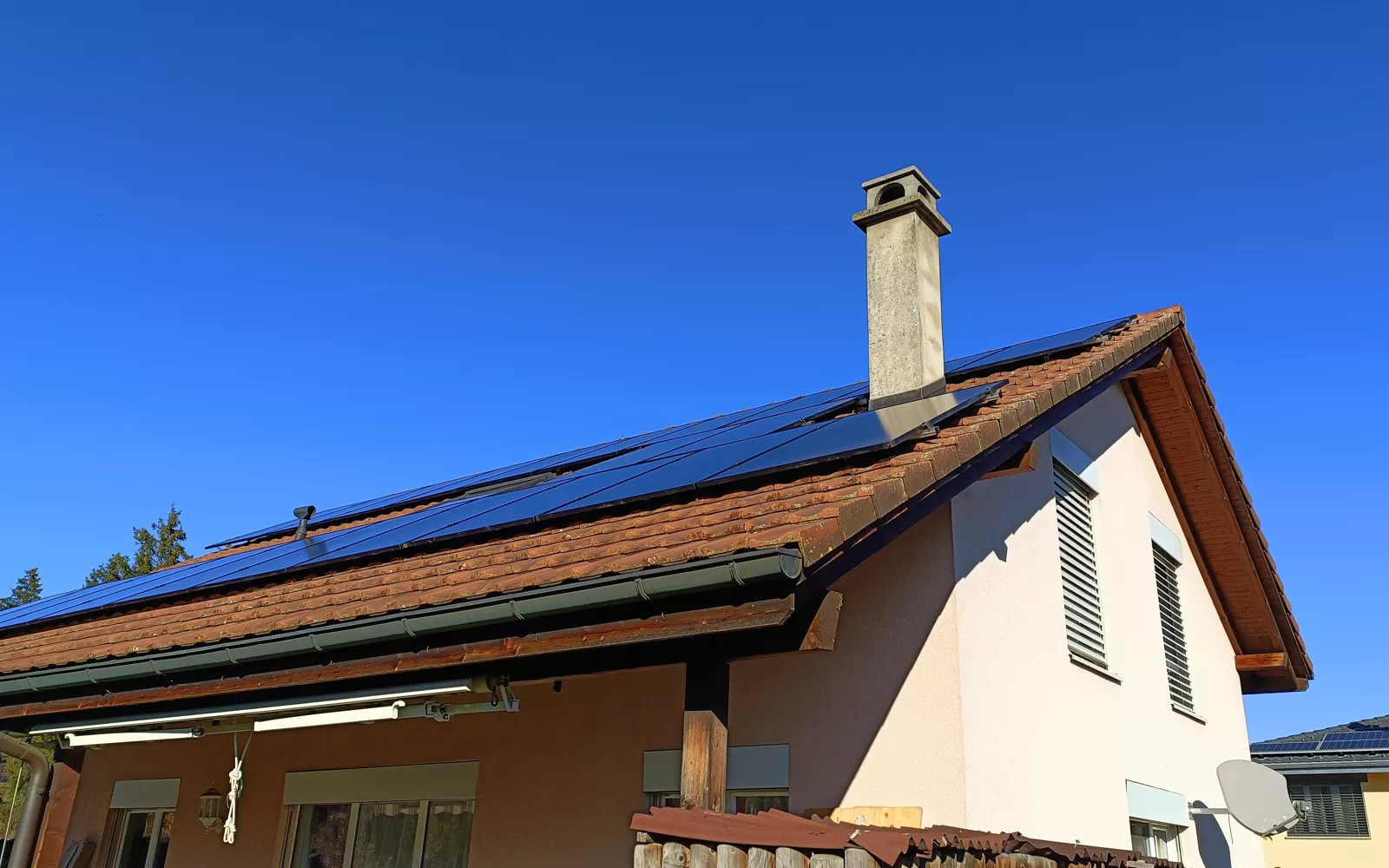 Vue latérale d'une installation de panneaux solaires photovoltaïques sur une villa à Riaz, près de Bulle (Canton de Fribourg).